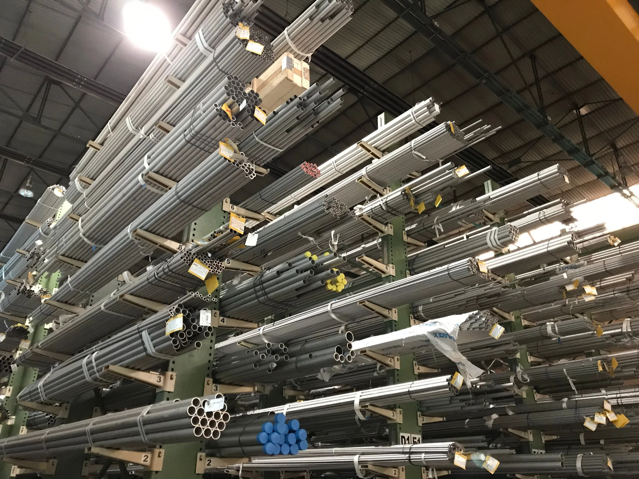 Bundles of metal tubes organized on industrial warehouse racks