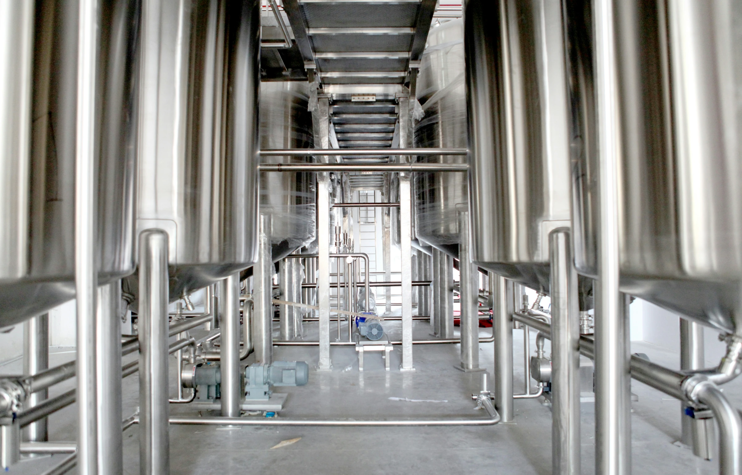 Stainless-steel processing tanks, valves and pumps in a clean industrial interior